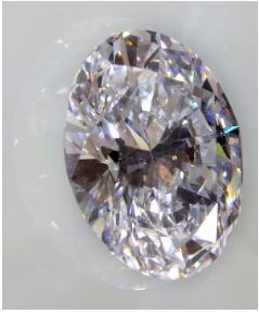 یک الماس سفید دایره ای که روی یک سطح سفید نشسته است.
